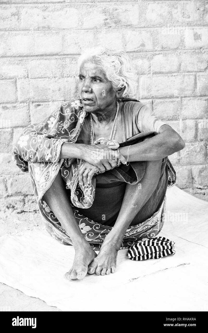 PUDUCHERRY, INDIA - DECEMBER Circa, 2018. Unidentified portrait of old face indian woman sitting outdoor in village, very serious. Black and white ima Stock Photo