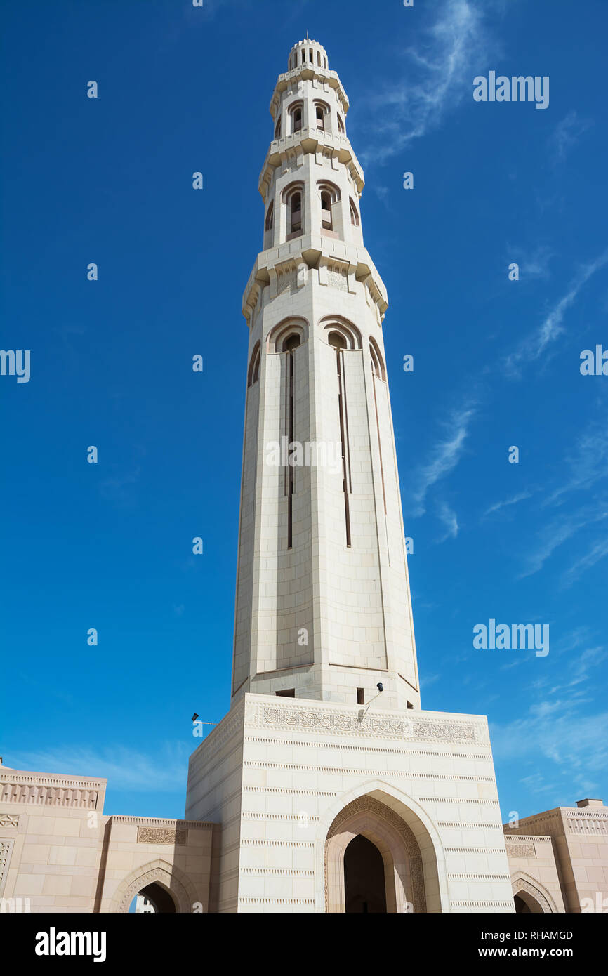 Minaret of the Muscat Grand Mosque silhouetted in the blue sky Stock Photo