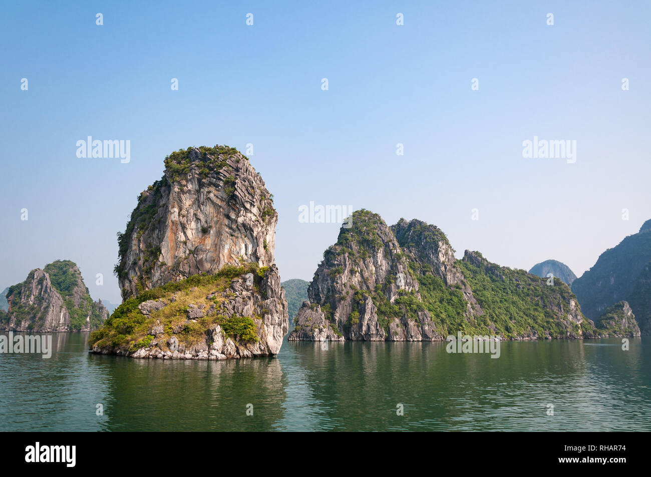 Limestone karst islets covered in vegetation in early morning light, Halong Bay, Vietnam Stock Photo