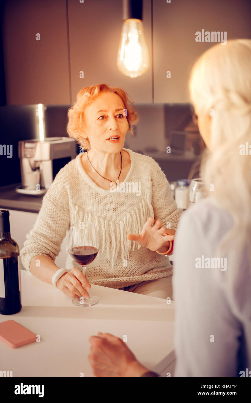 Nice aged woman sitting with a glass of wine Stock Photo - Alamy