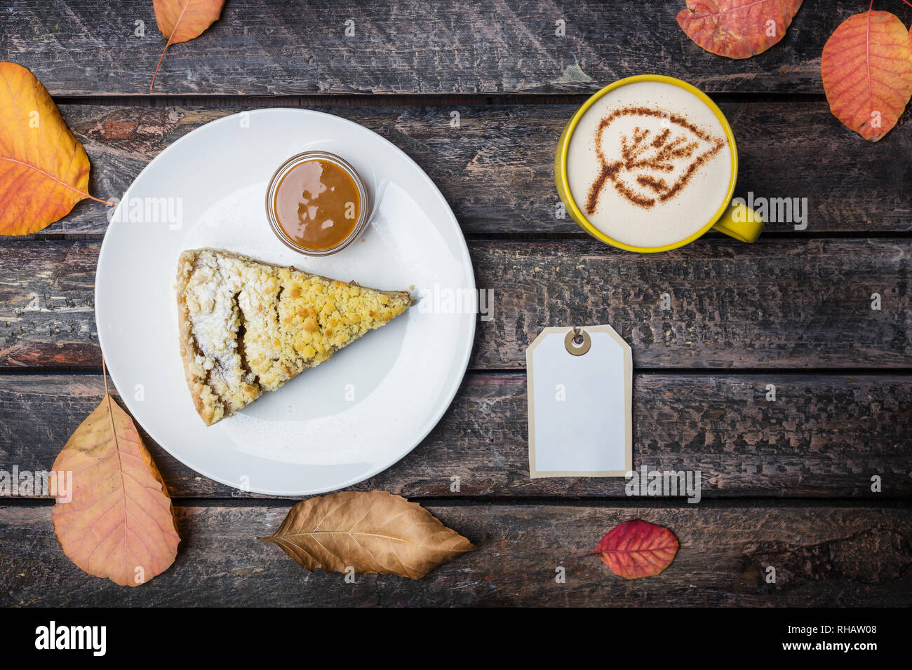 Apple pie with coffee on a white dish, on a beautiful wooden background. Top view autumn leaves. Stock Photo