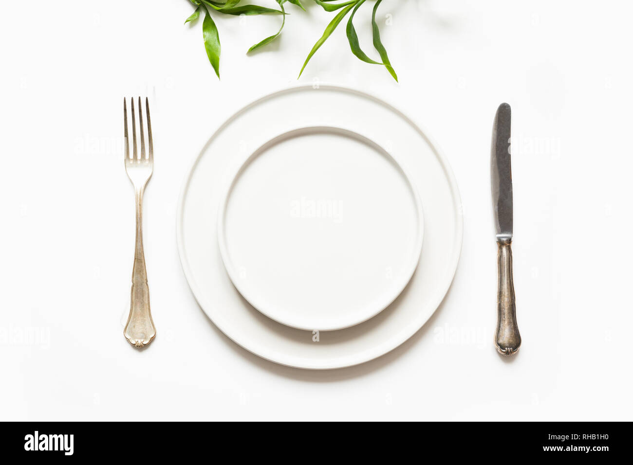 Minimal modern table setting for one person on white. View from above