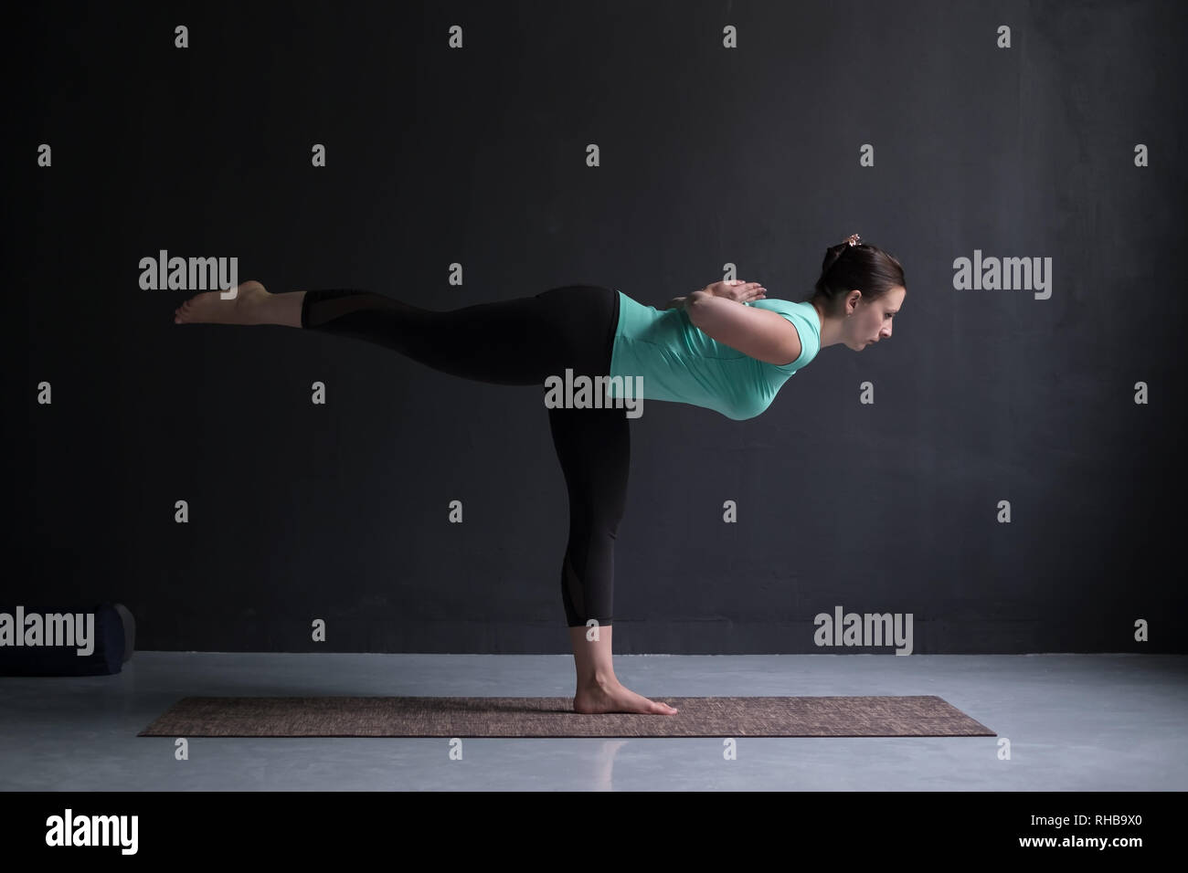 Sporty fit woman practices yoga asana Virabhadrasana 3 Stock Photo