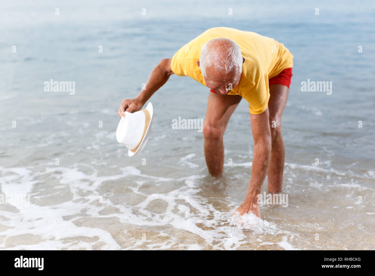 Man touches the water temperature on the beach Stock Photo Alamy