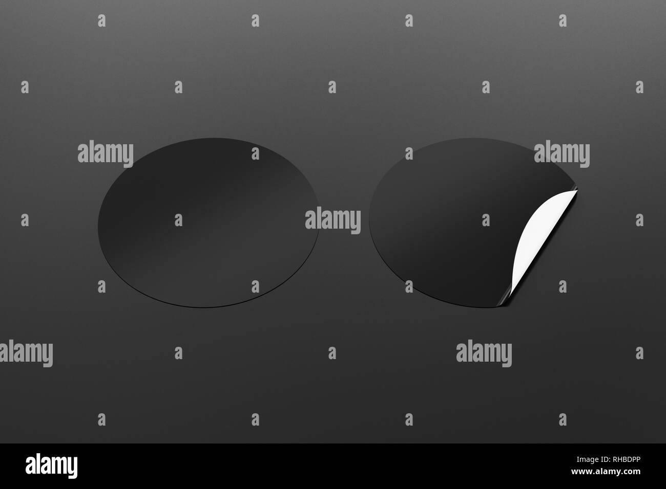 Blank black round stickers straightened and with folded corner on black ...