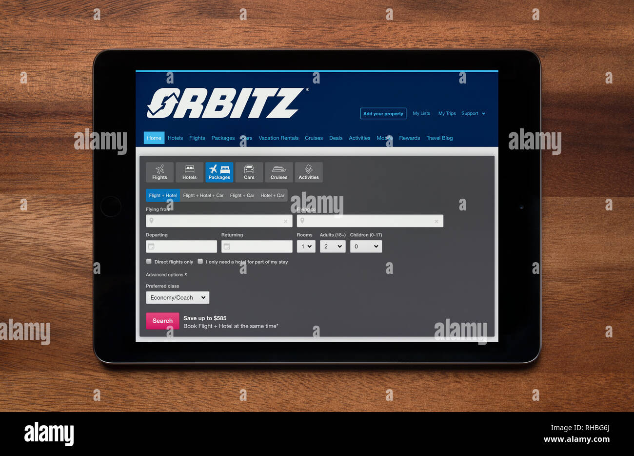 The website of Orbitz is seen on an iPad tablet, which is resting on a wooden table (Editorial use only). Stock Photo