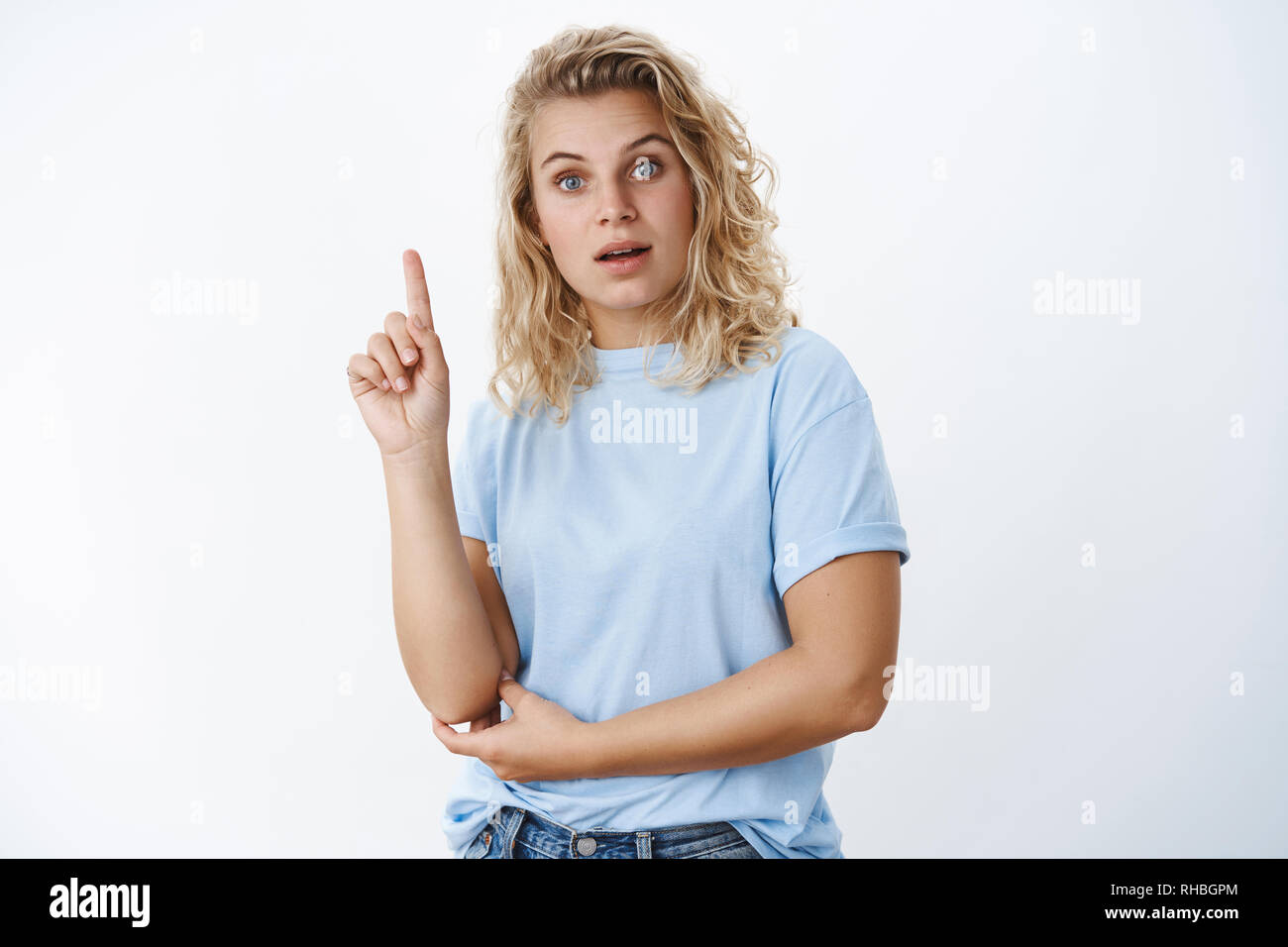 I got idea. Portrait of woman giving directions, having plan raising index finger in eureka gesture and talking to camera with smart and determined Stock Photo