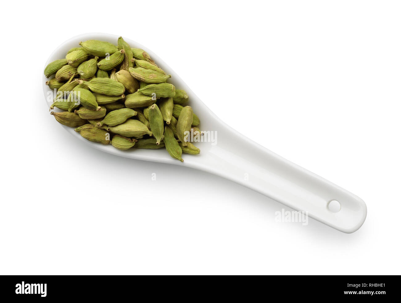 Top view of dried cardamom pods in  spoon isolated on white Stock Photo