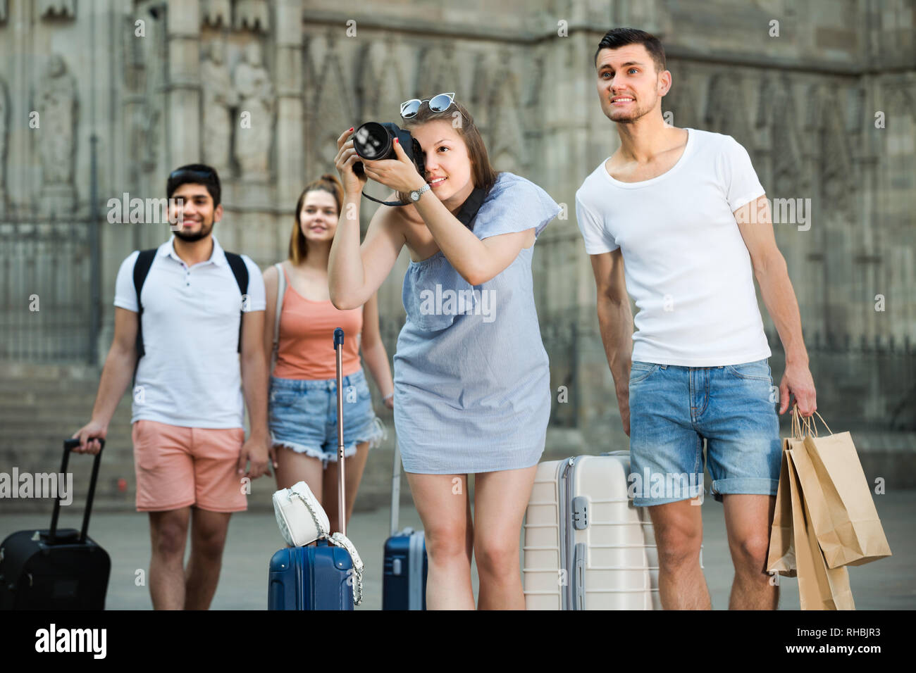 Young cheerful man and woman tourists are holding camera in hands and ...