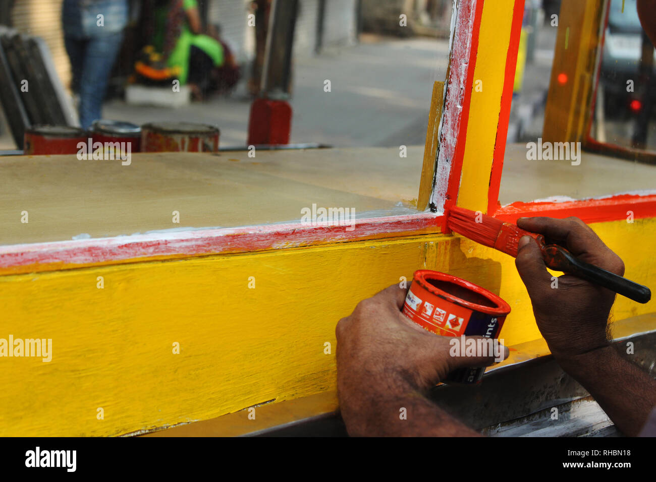 Man painting handcart with red color, Maharashtra, India Stock Photo