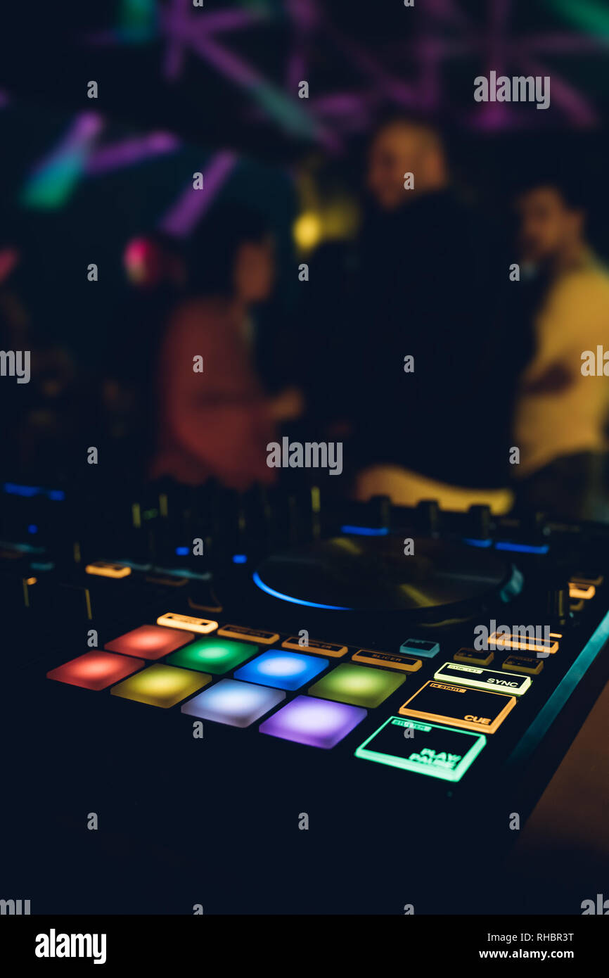 DJ plays live set and mixing music on turntable console at stage in the