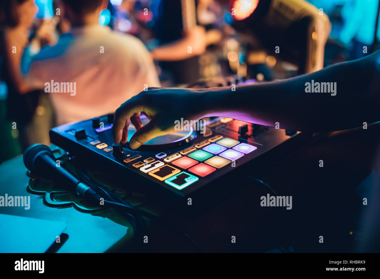 DJ plays live set and mixing music on turntable console at stage in the ...