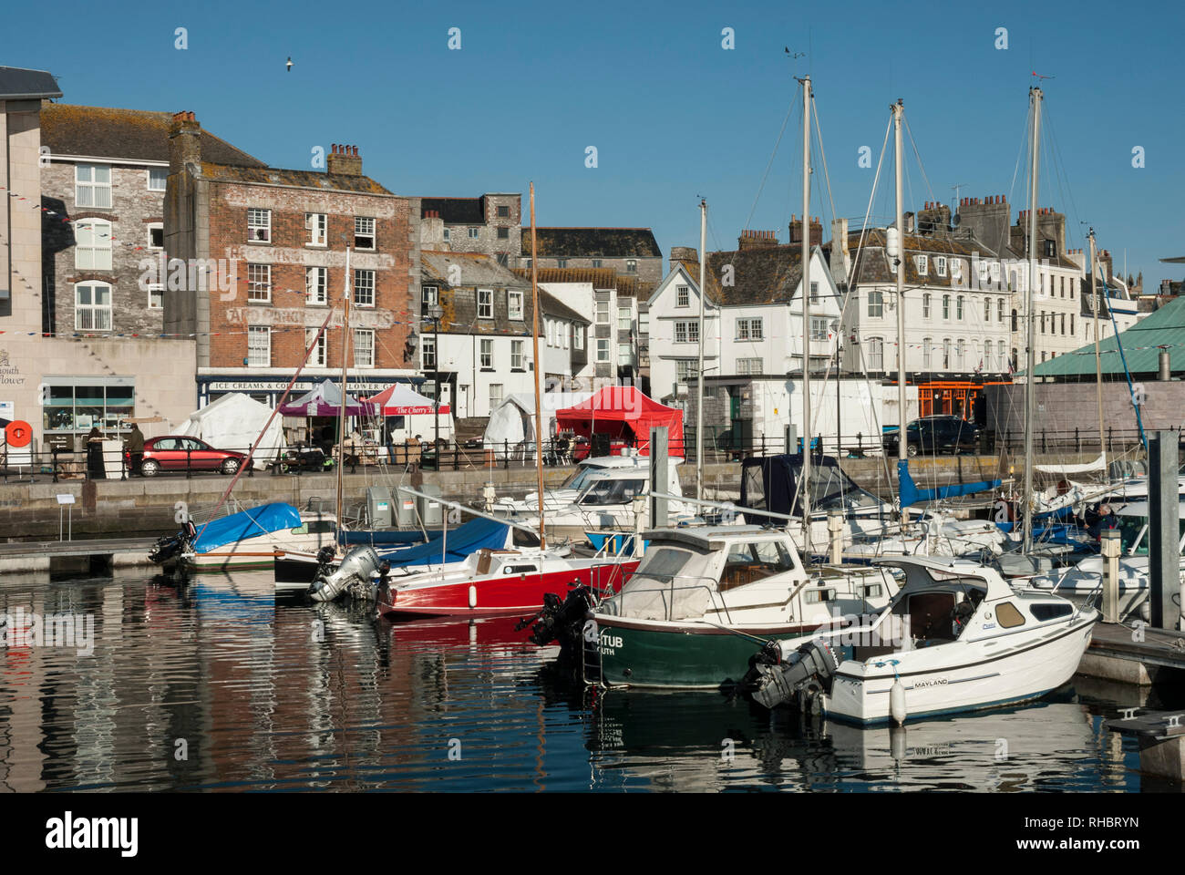 View across Barbican Marina/ Sutton Harbour, Barbican Plymouth. A sunny spring day with moored pleasure boats and historic buildings Stock Photo