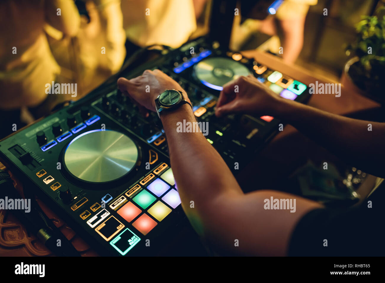 DJ plays live set and mixing music on turntable console at stage in the