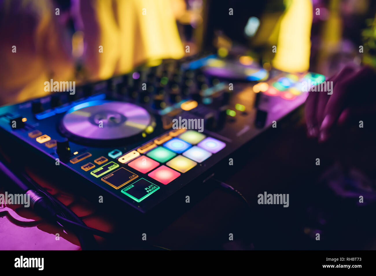 DJ plays live set and mixing music on turntable console at stage in the