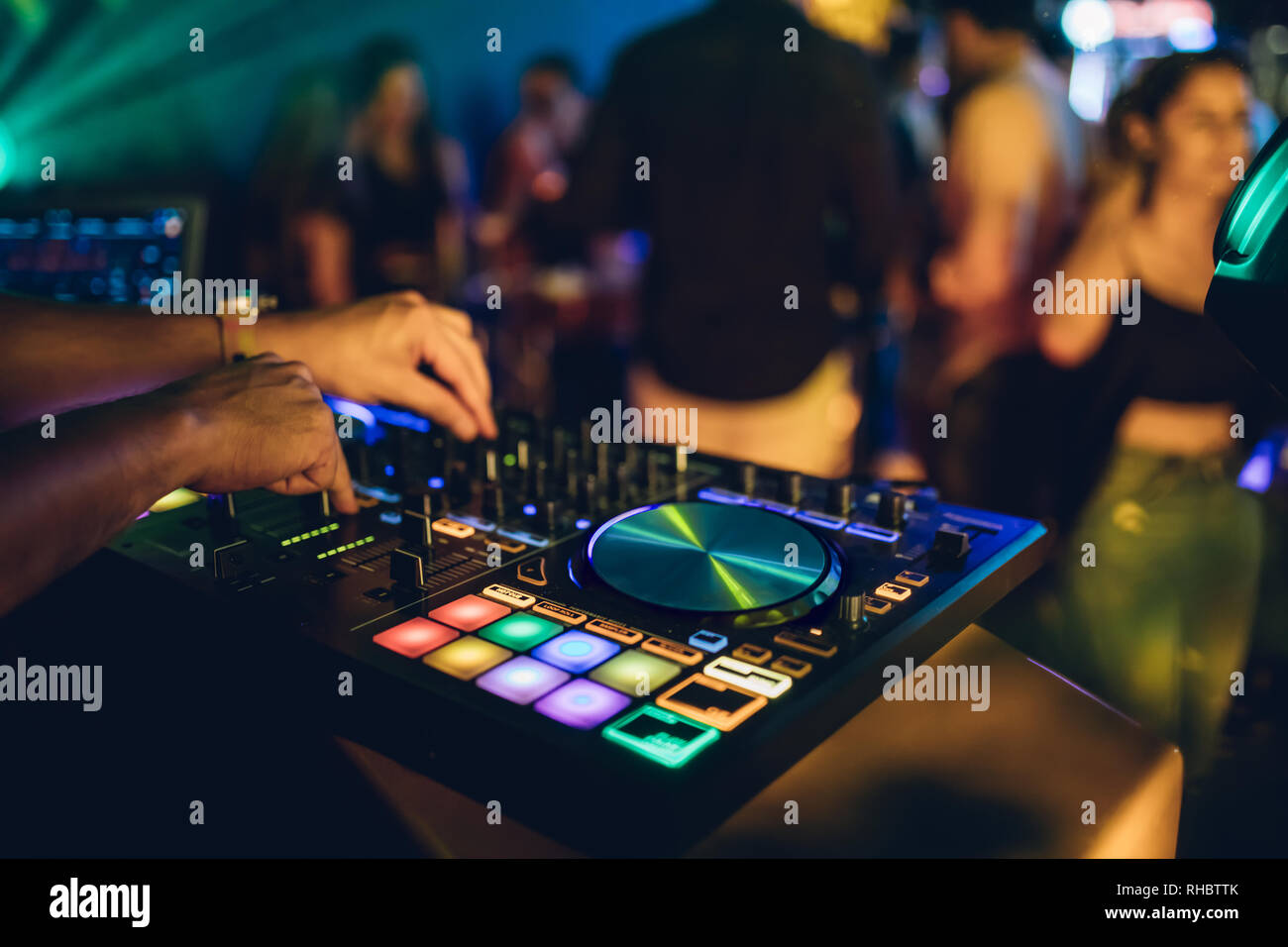 DJ plays live set and mixing music on turntable console at stage in the