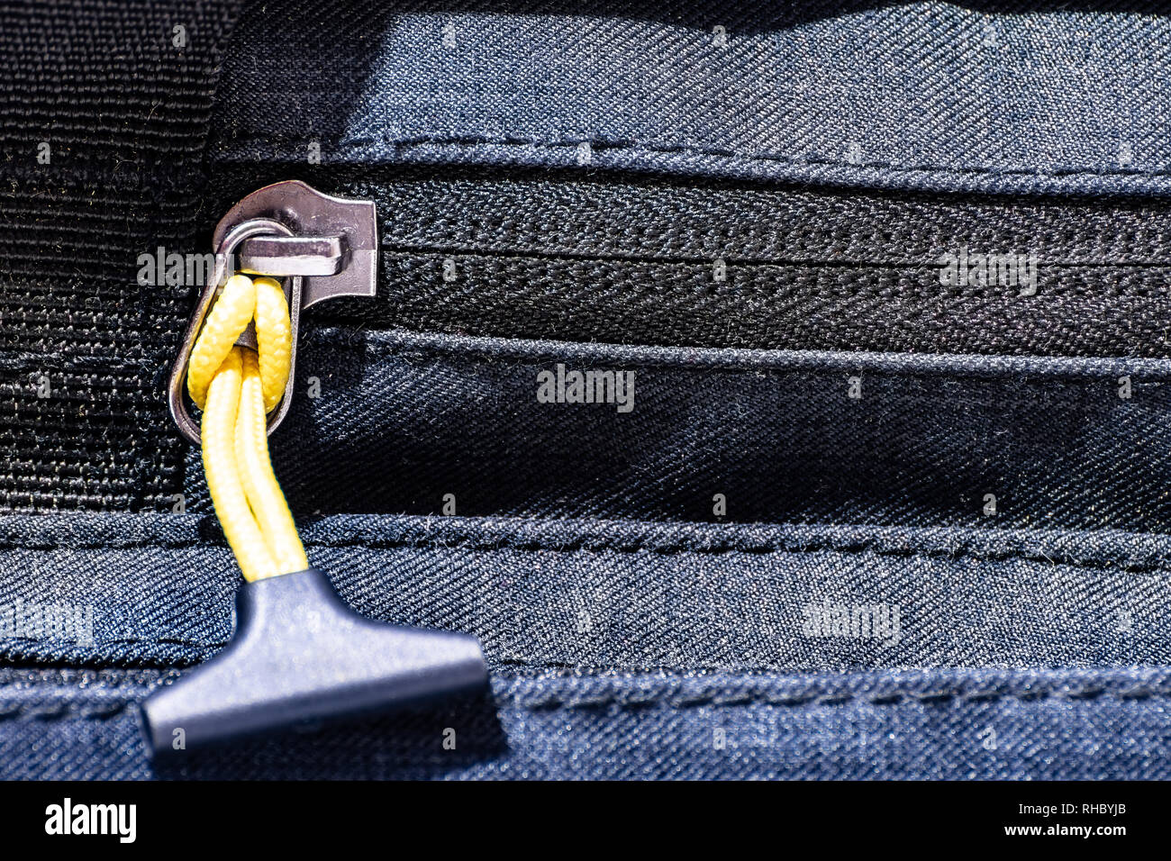 Close up on zipper of a travel bag with yellow cord and plastic on the end Stock Photo