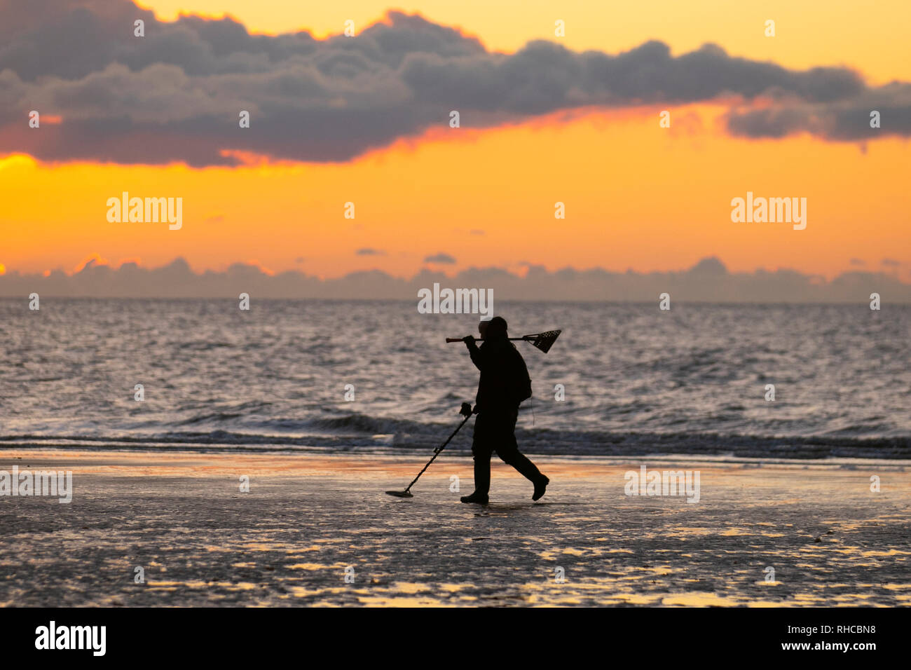Two metal detectorists with a shovel and a spade scour Blackpool beach