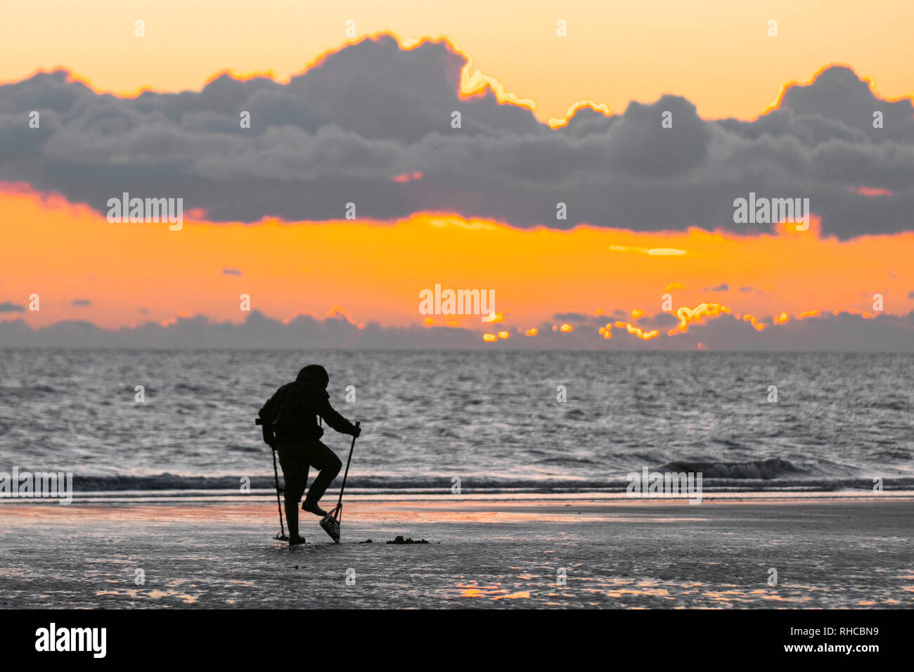 Metal detectorists with a shovel and a spade scour Blackpool beach for