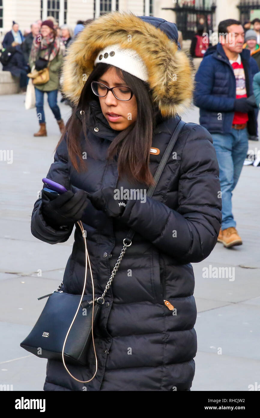 A woman is seen wrapped up warm in a a scarf and hood on a very cold day in  London Stock Photo - Alamy