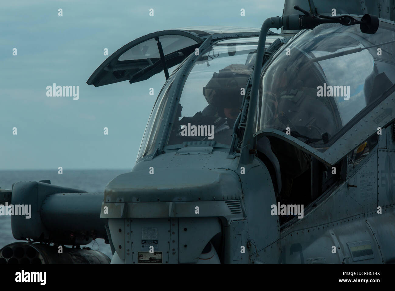 A Marine naval aviator with Marine Medium Tiltrotor Squadron 262 (Reinforced) performs pre-flight checks inside an AH-1Z Super Cobra helicopter atop the flight deck of the amphibious transport dock USS Green Bay (LPD 20) during flight operations at sea, Jan. 19, 2019. VMM-262 (Rein.) is the Aviation Combat Element for the 31st Marine Expeditionary Unit. The 31st MEU, the Marine Corps’ only continuously forward-deployed MEU partnering with the Wasp Amphibious Ready Group, provides a flexible and lethal force ready to perform a wide range of military operations as the premier crisis response for Stock Photo