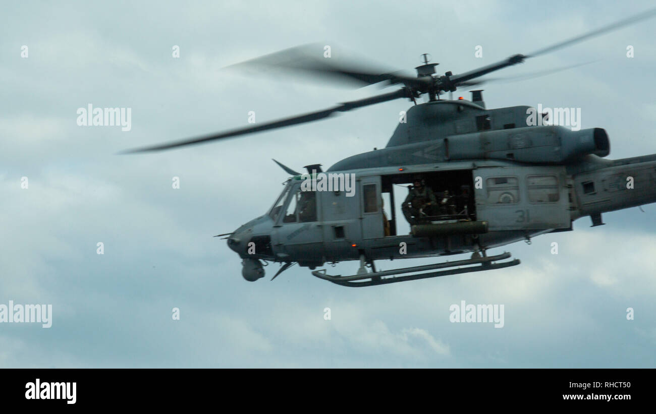 A UH-1Y Huey helicopter belonging to Marine Medium Tiltrotor Squadron 262 (Reinforced) leaves the flight deck of the amphibious transport dock USS Green Bay (LPD 20) during flight operations at sea, Jan. 19, 2019. VMM-262 (Rein.) is the Aviation Combat Element for the 31st Marine Expeditionary Unit. The 31st MEU, the Marine Corps’ only continuously forward-deployed MEU partnering with the Wasp Amphibious Ready Group, provides a flexible and lethal force ready to perform a wide range of military operations as the premier crisis response force in the Indo-Pacific region. (U.S. Marine Corps photo Stock Photo