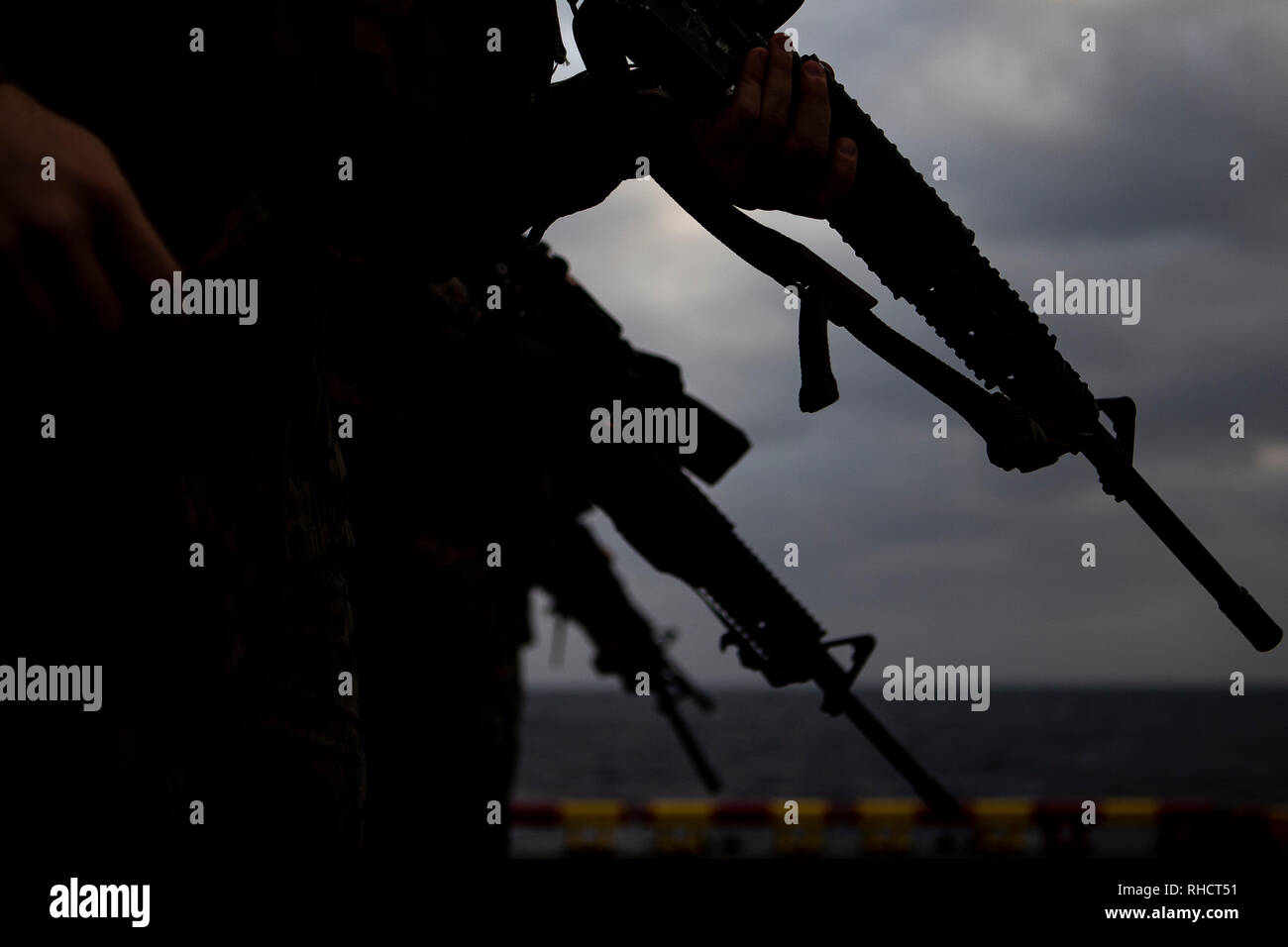 Marines with Combat Logistics Battalion 31 stand atop an aircraft elevator during a small-arms deck shoot aboard the amphibious assault ship USS Wasp (LHD 1), underway in the Philippine Sea, Feb. 1, 2019. Marines with CLB-31, the Logistics Combat Element for the 31st Marine Expeditionary Unit, honed their marksmanship and targeting capabilities during the exercise. The 31st MEU, the Marine Corps’ only continuously forward-deployed MEU partnering with the Wasp Amphibious Ready Group, provides a flexible and lethal force ready to perform a wide range of military operations as the premier crisis  Stock Photo