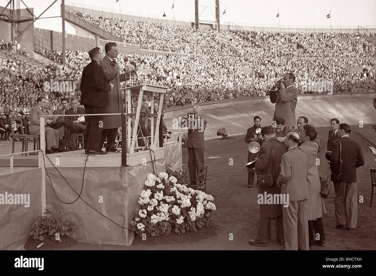 Billy Graham preaching at Olympic Stadium in Amsterdam, North Holland on June 22, 1954. Stock Photo