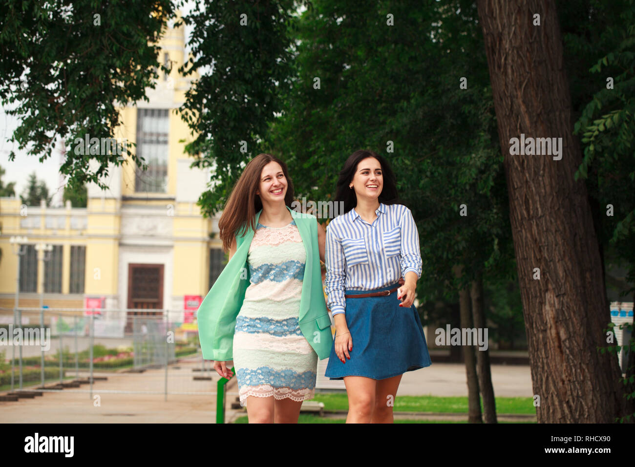 Two happy women walking in the summer park Stock Photo - Alamy