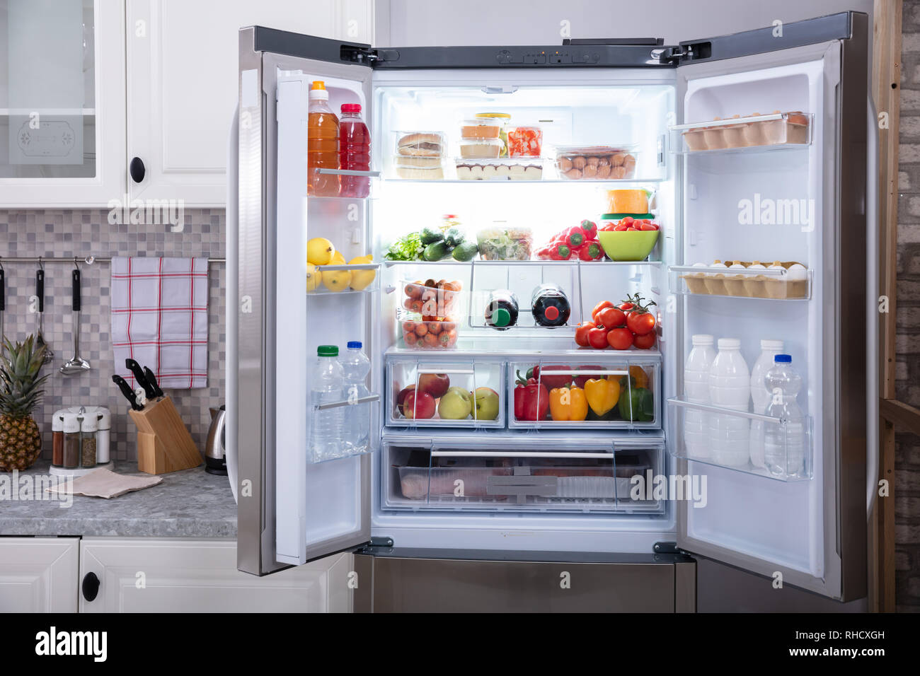 An Open Refrigerator Filled With Fresh Fruits And Vegetables Stock