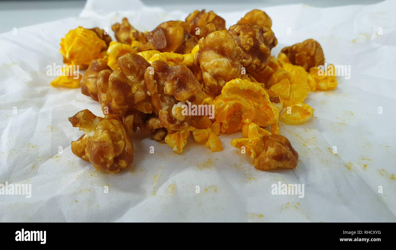 Caramel-flavored popcorn snacks on a tissue at the table Stock Photo