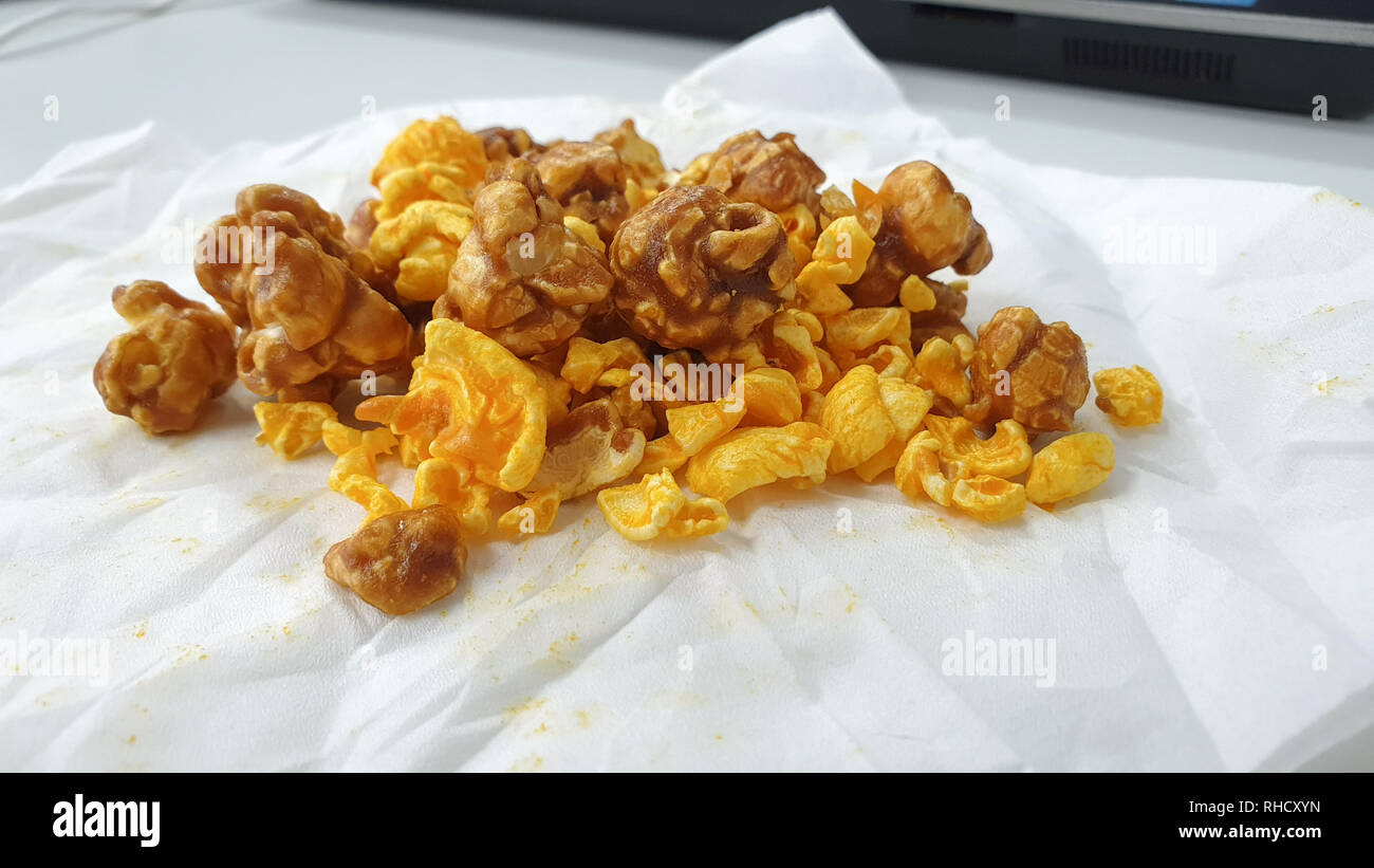 Caramel-flavored popcorn snacks on a tissue at the table Stock Photo