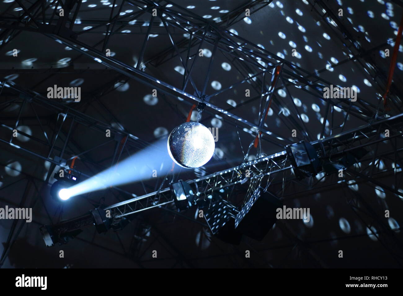 Reflections and spots of shining ceiling glitterball in the ray of spotlight Stock Photo