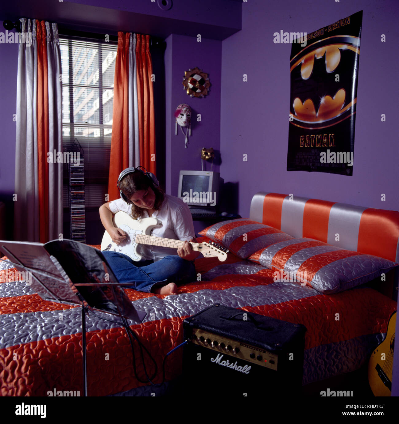Teenager playing guitar in bedroom Stock Photo