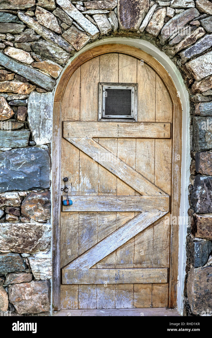 Arched Door. Exterior wooden weathered wine cellar door with small