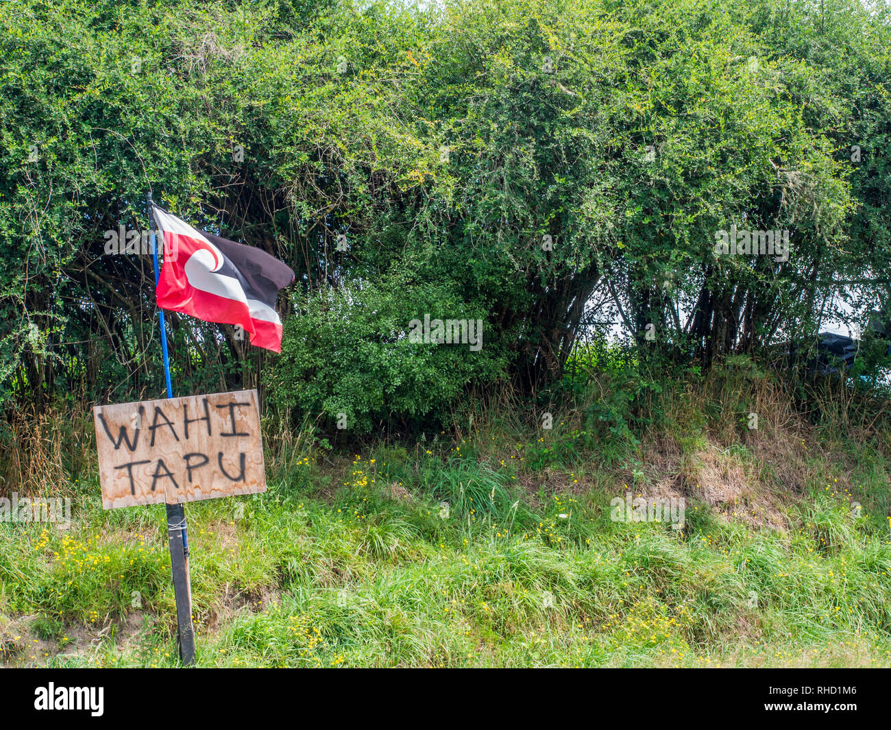 Tino Rangatiratanga Māori flag and sign marking site of wahi tapu sacred place, unlawfully taken now a farm, near Murapara, Bay of Plenty, New Zealand Stock Photo