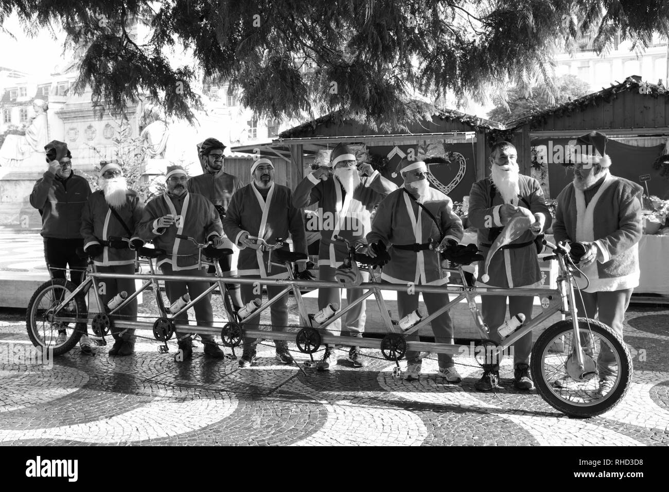 Men Dressed as Santa Claus Father Christmas riding a six seater bike Lisbon Portugal Stock Photo