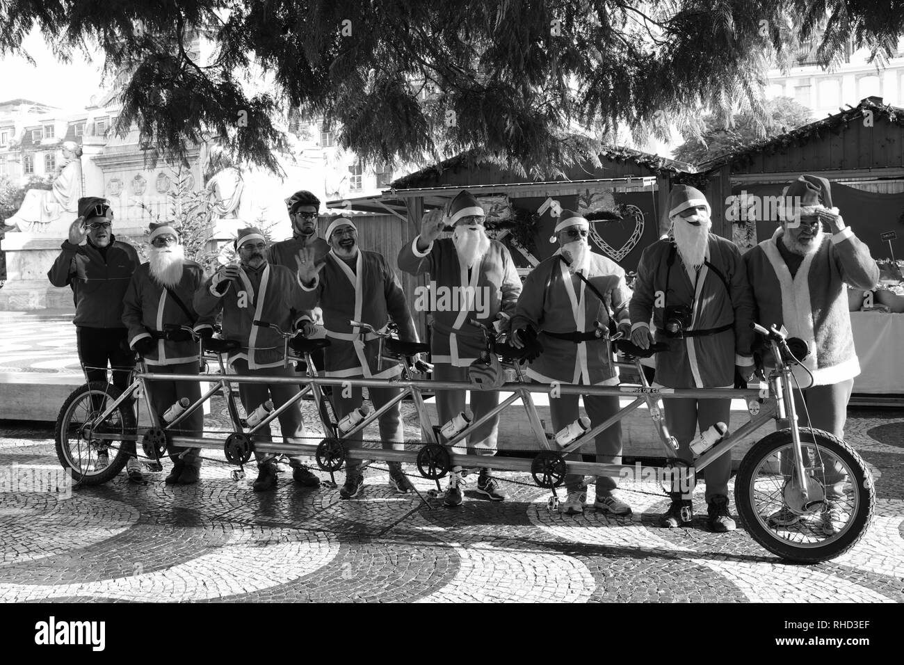 Men Dressed as Santa Claus Father Christmas riding a six seater bike Lisbon Portugal Stock Photo