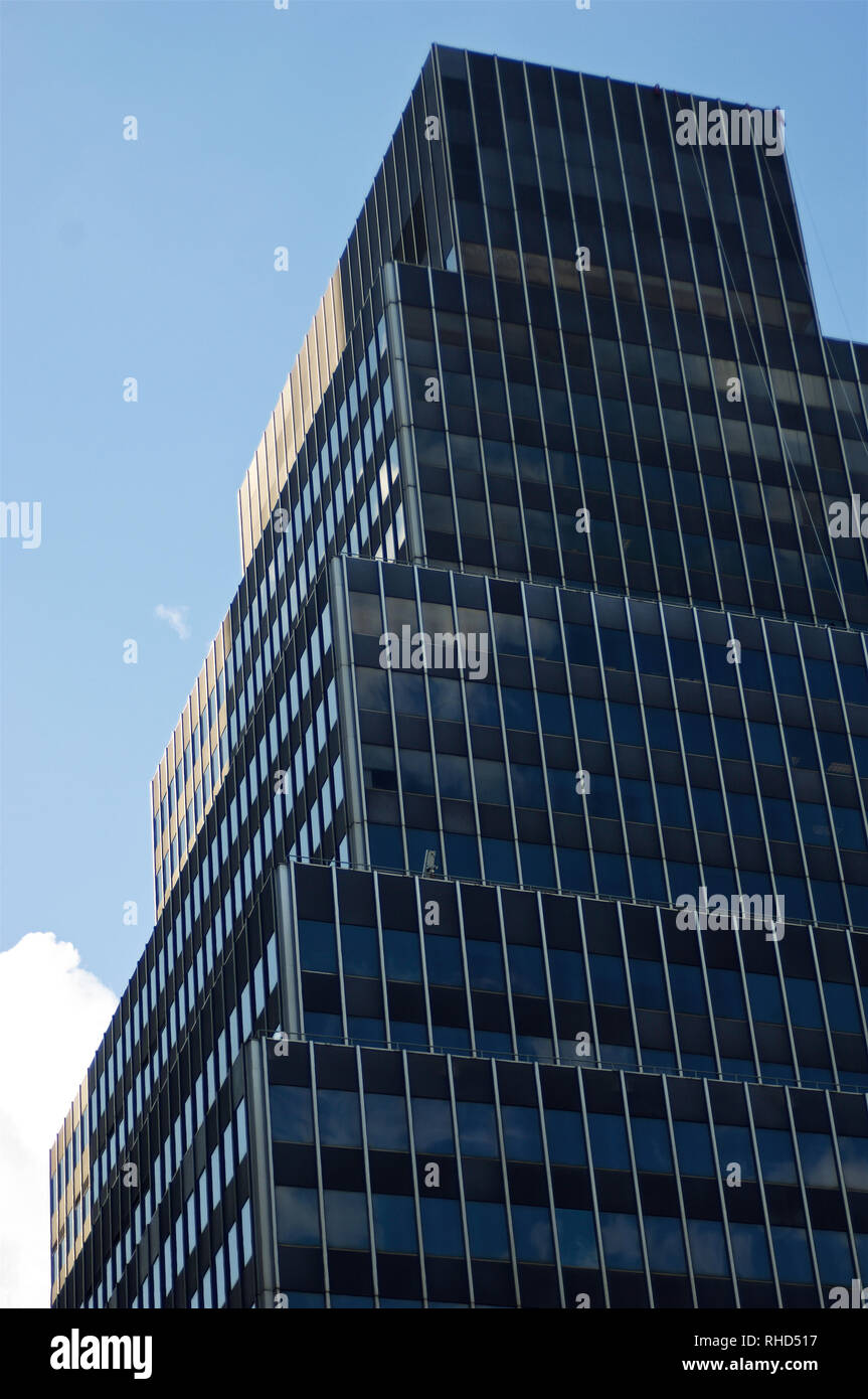 A stack or layers of dark architectural blocks set against a blue sky ...