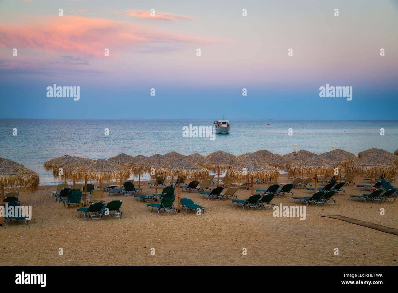 Beach umbrella at sunset, view of chairs and umbrellas on the beach