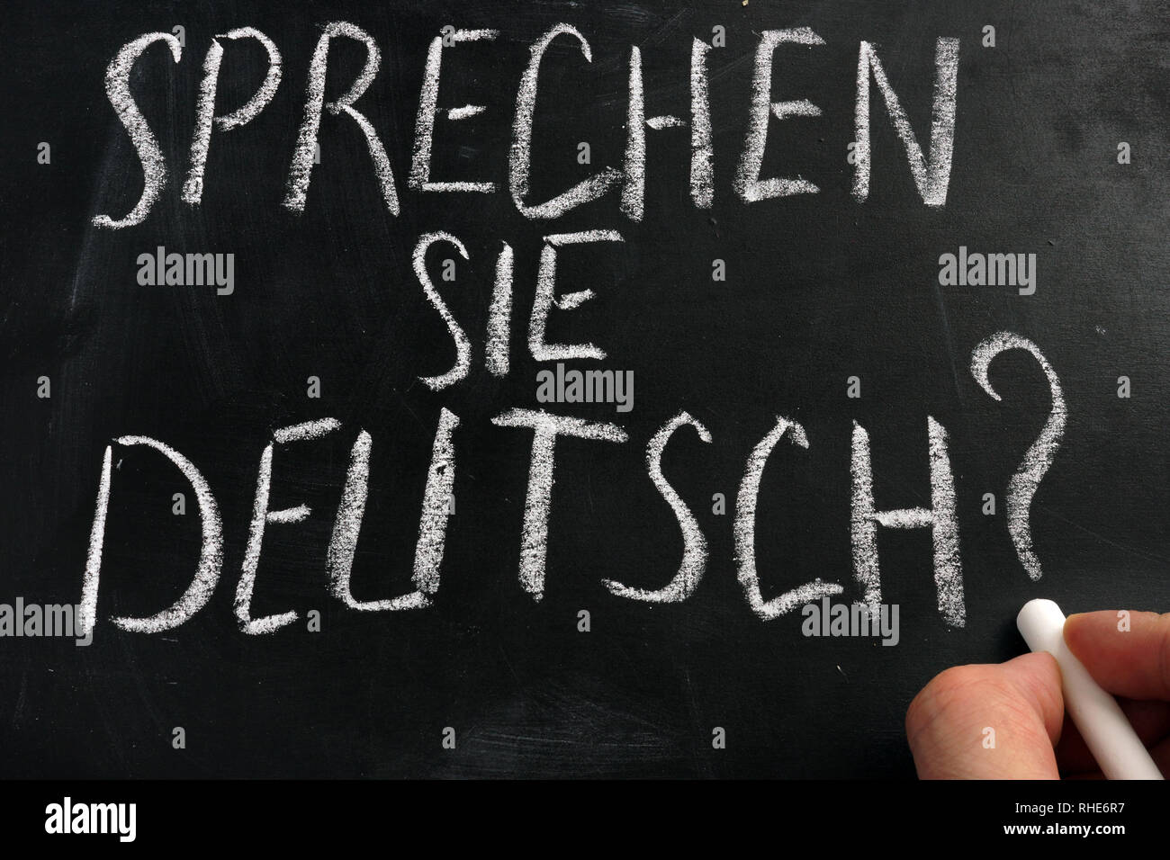 Learn German concept. Sprechen Sie Deutsch sign on a blackboard. Stock Photo