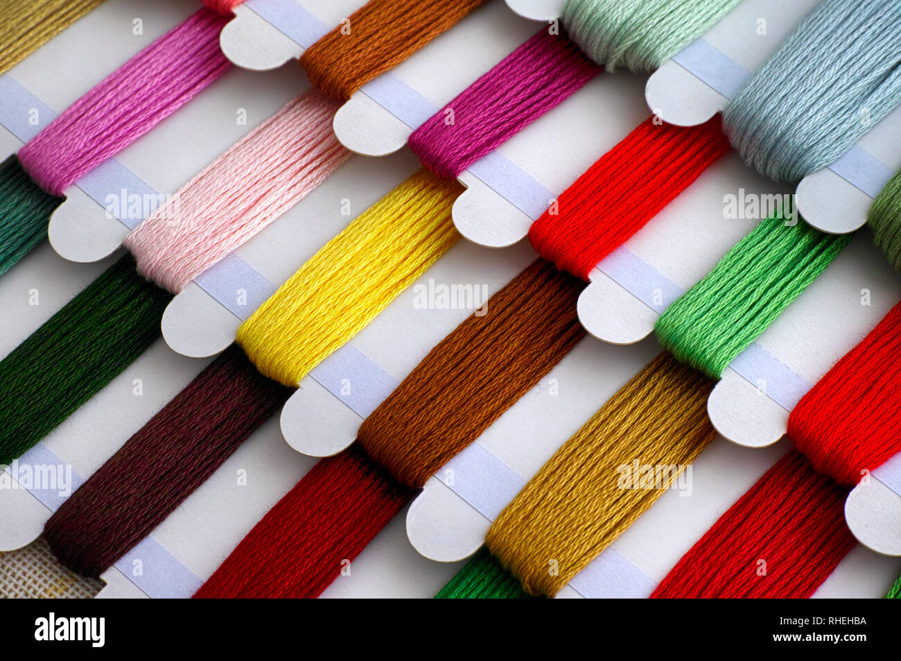 Colored embroidery threads on spools ready for cross stitch. Close-up. Stock Photo