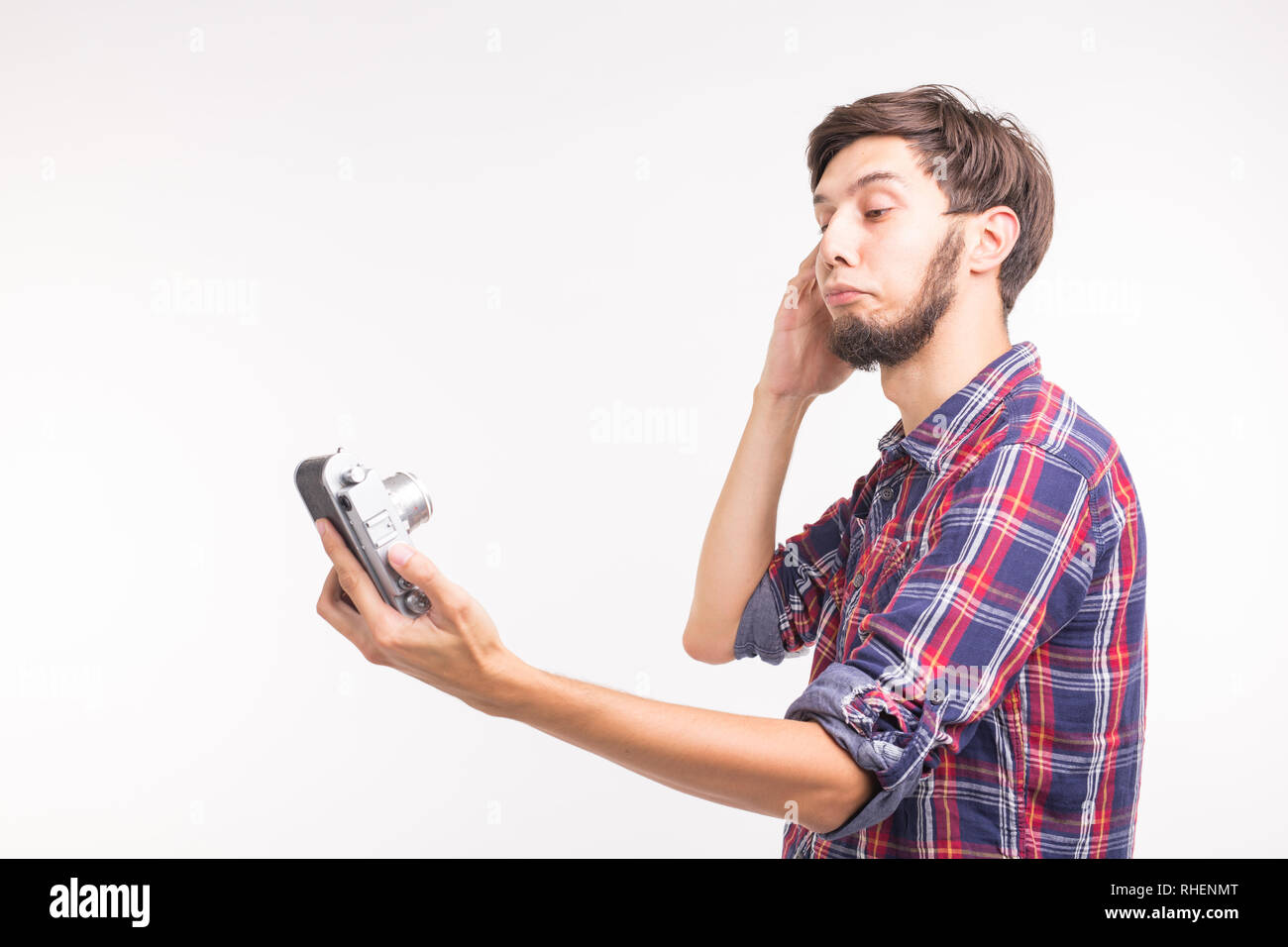 Technology, photography and people concept - Handsome man in plaid shirt taking a selfies on vintage camera Stock Photo