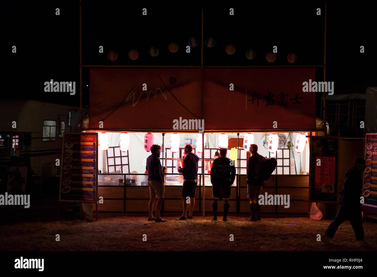 Four men wait for food outside a festival stall Stock Photo