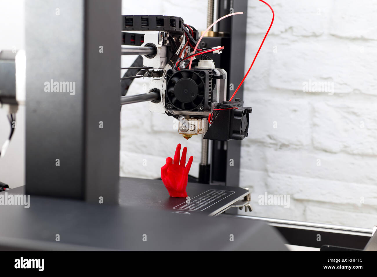 3d Printer prints a red plastic hand figurine Stock Photo