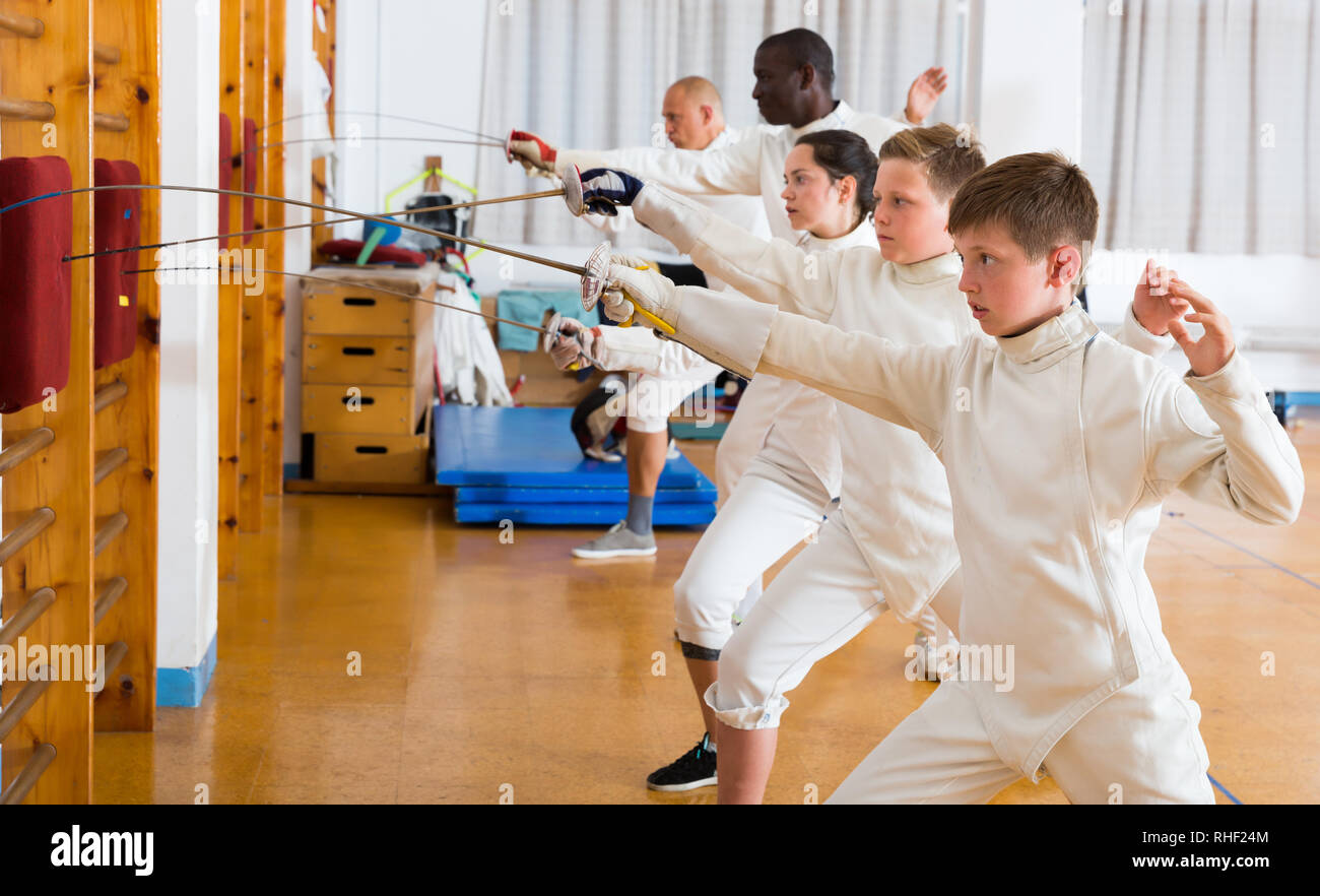 Positive mixed age group of athletes at fencing workout, training