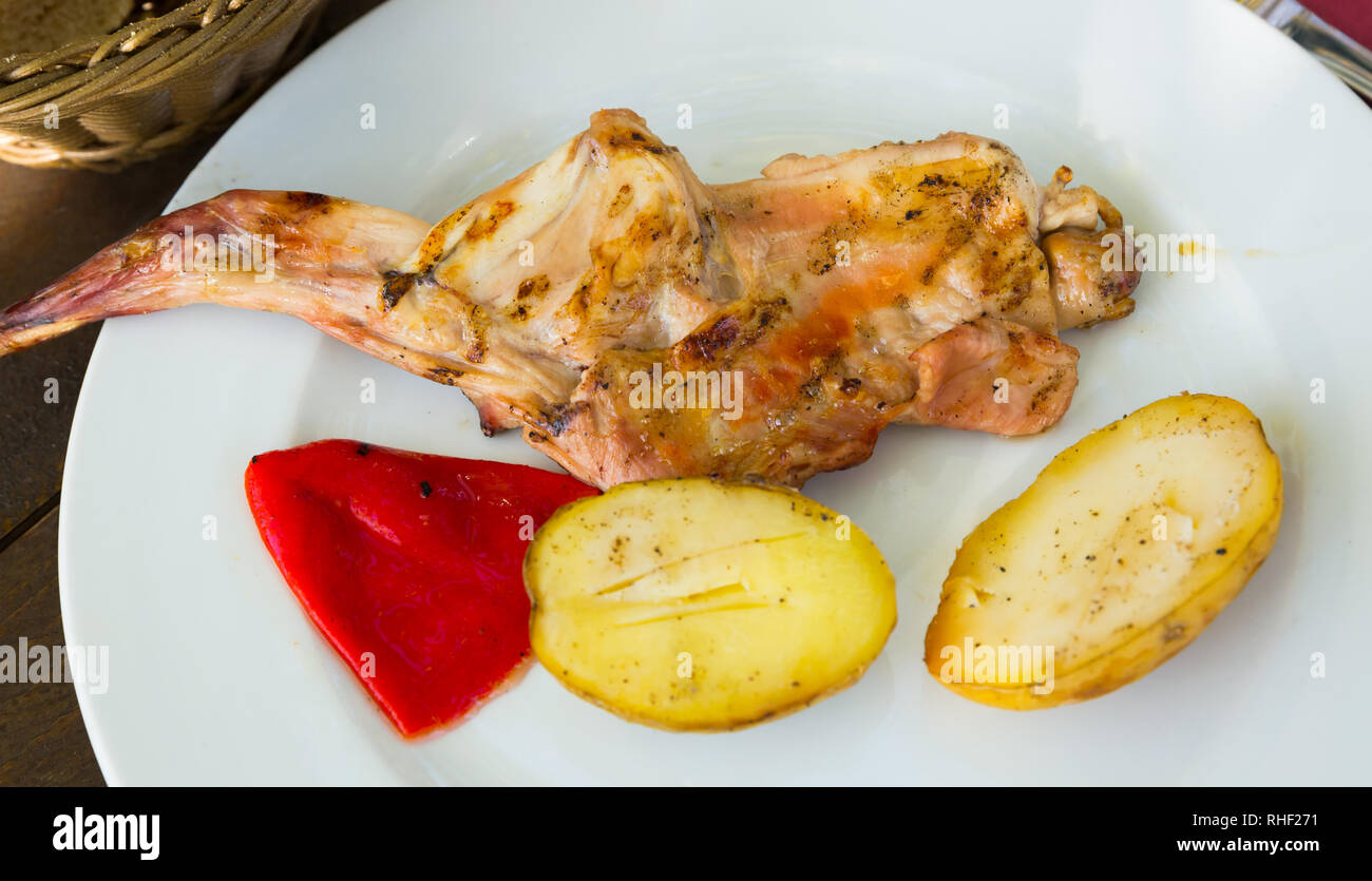 Delicious fried rabbit served with baked potatoes and bell pepper on ...