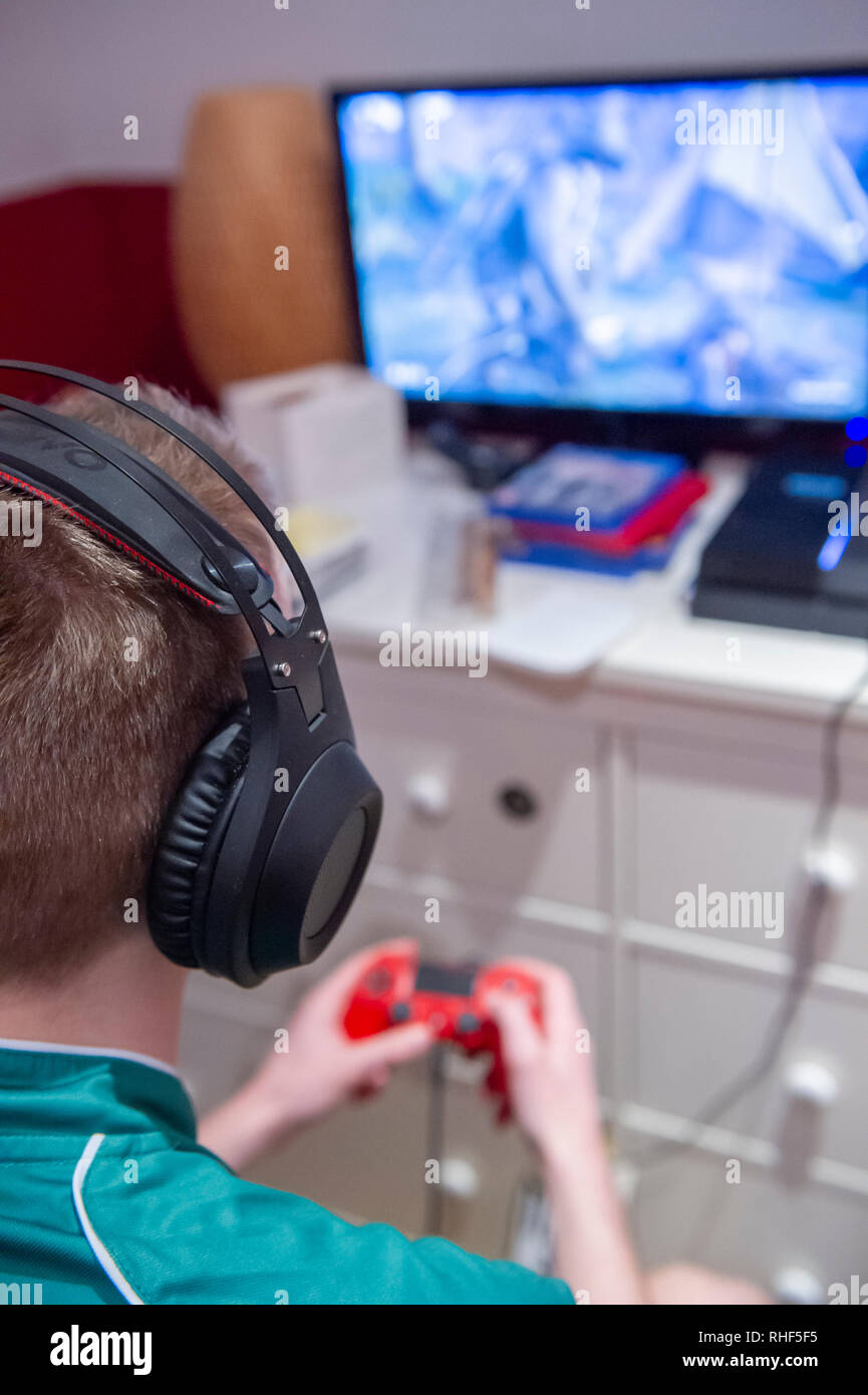 A Teenaged Boy Playing Computer Games In His Bedroom Stock