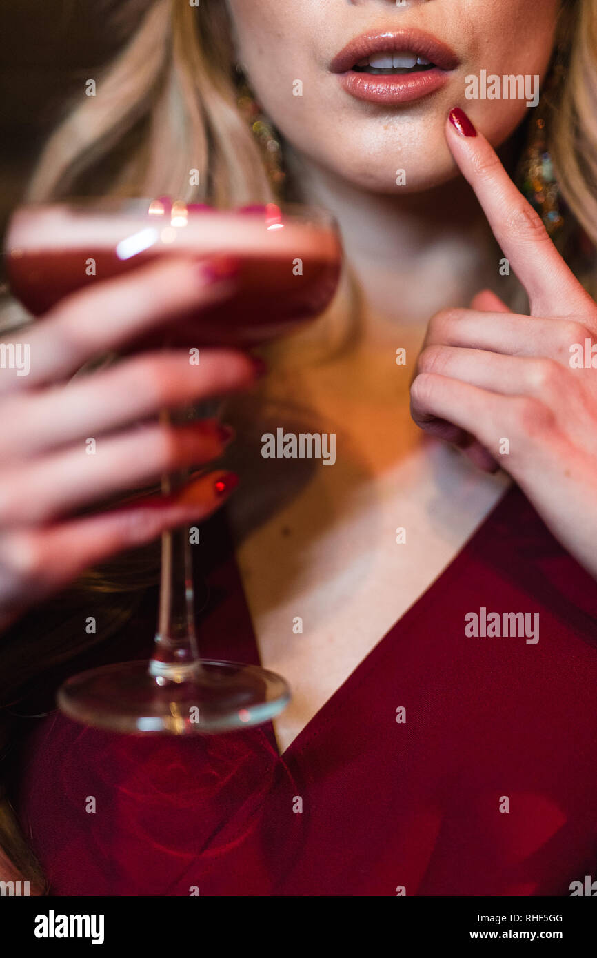 A young blonde woman poses with a pink cocktail Stock Photo