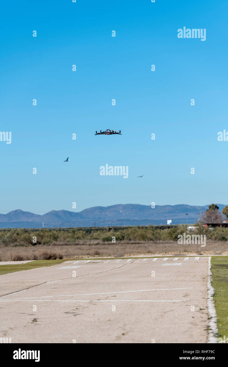 Professional drone flying over the airfield in hover Stock Photo